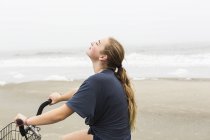 Jeune fille à vélo sur le sable à la plage, île Saint-Simons (Géorgie) — Photo de stock