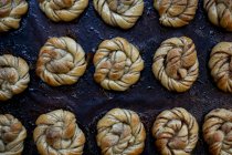 Grand angle gros plan du plateau avec des petits pains à la cannelle fraîchement cuits dans une boulangerie artisanale . — Photo de stock