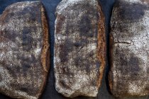 Grand angle gros plan de trois pains fraîchement cuits dans une boulangerie artisanale . — Photo de stock