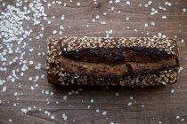 High angle close up of freshly baked seeded loaf of bread in an artisan bakery. — Stock Photo