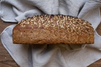 High angle close up of freshly baked seeded loaf of bread in an artisan bakery. — Stock Photo