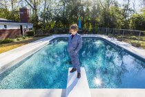 6 anno vecchio ragazzo standing su diving board con vista piscina — Foto stock