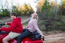 Deux adolescents sur un buggy, véhicule tout terrain sur une piste boueuse. — Photo de stock