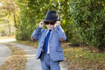 6 year old boy dressed in suit and wearing fedora, in driveway — Stock Photo