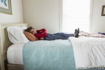 6 anno vecchio ragazzo riposo su suo letto — Foto stock