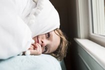 6-jähriger Junge im Bett mit Decken über dem Kopf — Stockfoto