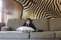 6-jähriger Junge sitzt auf Sofa — Stockfoto
