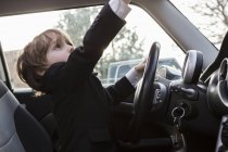 6 anno vecchio ragazzo seduta in auto holding volante — Foto stock