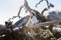 6 anos de idade menino escalando em árvores maciças deitado na água do oceano, Driftwood Beach, Jekyll Island, Geórgia — Fotografia de Stock