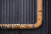 Оранжевая водосточная труба против стены склада, закрыть — стоковое фото