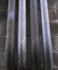 Tuyauterie métallique contre mur de construction — Photo de stock