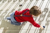 6 anno vecchio ragazzo giocare con giocattolo automobili su terrazza — Foto stock