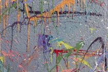 Colorful graffiti paint splatters on urban wall, abstract background — Stock Photo