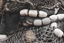 Vista de perto da pilha de redes de pesca comerciais e redes de emalhar num cais de pesca — Fotografia de Stock