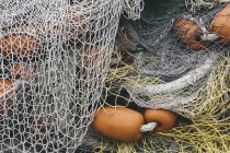 Pilha de redes de pesca comerciais e redes de emalhar num cais de pesca, close-up — Fotografia de Stock