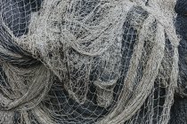 Pilha de redes de pesca comerciais e redes de emalhar num cais de pesca — Fotografia de Stock