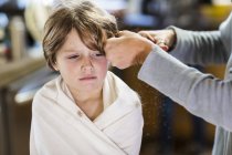 Tiro cortado de mãe corte de cabelo para filho adorável em casa — Fotografia de Stock