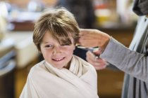 Plan recadré de la mère coupe les cheveux à adorable fils à la maison — Photo de stock