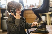Ragazzo di sei anni in giacca e cravatta che parla su un vecchio telefono vintage a casa — Foto stock