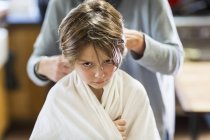 Madre che taglia i capelli al figlio adorabile a casa — Foto stock