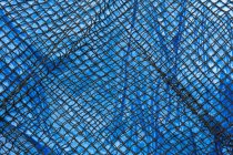 Détail du filet de pêche commercial recouvrant la bâche bleue — Photo de stock