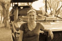 Porträt einer Frau, die sich an ein Safari-Fahrzeug lehnt — Stockfoto