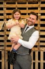 Portrait of bearded man hugging his young daughter during naming ceremony in an historic barn. — Stock Photo