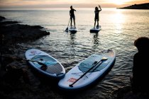 Colpo ad angolo alto di persone sui paddleboard al tramonto. — Foto stock