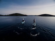 High angle shot of two people on paddleboards. — Stock Photo