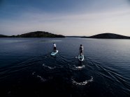 Plan grand angle de deux personnes sur des planches à pagaie. — Photo de stock