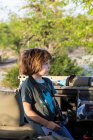 Ein fünfjähriger Junge hält ein Fernglas in einem Safari-Fahrzeug. — Stockfoto