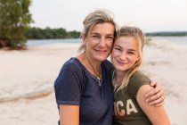 Reife Frau und ein junges Teenager-Mädchen, Mutter und Tochter am Ufer eines breiten Flusses. — Stockfoto