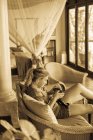 12-jähriges Mädchen blickt in einem Hotelzimmer in Botsuana auf ihr Smartphone — Stockfoto