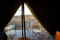 Donna che scatta una fotografia al tramonto, nel deserto del Kalahari. — Foto stock