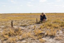 Chica de 12 años mirando Meerkats, desierto de Kalahari - foto de stock