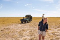 Chica de 12 años con Meerkat en la cabeza, desierto de Kalahari - foto de stock