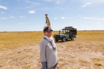 Donna adulta con Meerkat in testa, Kalahari Desert, Makgadikgadi Salt Pans, Botswana — Foto stock