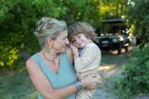 Woman, mother carrying her five year old son at a wildlife reserve camp. — Stock Photo