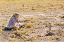Chica de 12 años mirando Meerkats, Desierto de Kalahari, Salinas Makgadikgadi, Botswana - foto de stock