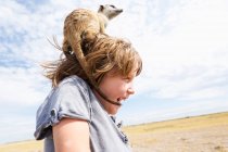 5-jähriger Junge mit Erdmännchen auf dem Kopf, Kalahari Wüste, Makgadikgadi Salzpfannen, Botswana — Stockfoto