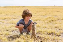 Ragazzo di 5 anni che guarda Meerkat, Kalahari Desert, Makgadikgadi Salt Pans, Botswana — Foto stock