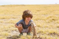 Garçon de 5 ans regardant Meerkat, désert du Kalahari, casseroles de sel Makgadikgadi, Botswana — Photo de stock