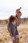 Garçon et fille de 5 ans avec Meerkat sur la tête, désert du Kalahari, casseroles de sel Makgadikgadi, Botswana — Photo de stock