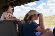 Hermano y hermana en vehículo safari - foto de stock