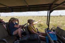 Madre e hija en vehículo safari - foto de stock