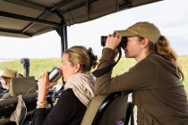 Ragazza di 13 anni con binocolo su veicolo safari, Botswana — Foto stock