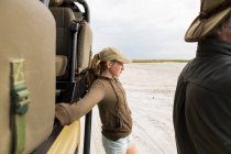 13 ans fille appuyé sur un véhicule safari, Botswana — Photo de stock