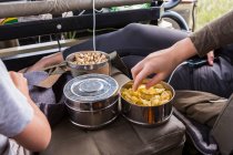 Cropped shot of hands reaching for snacks in safari vehicle — Stock Photo