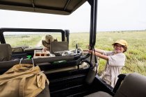 Menino de seis anos segurando em um veículo safari inclinado para fora. — Fotografia de Stock