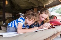 Frère et sœur faisant leurs devoirs ensemble dans un camp de tentes au Botswana — Photo de stock